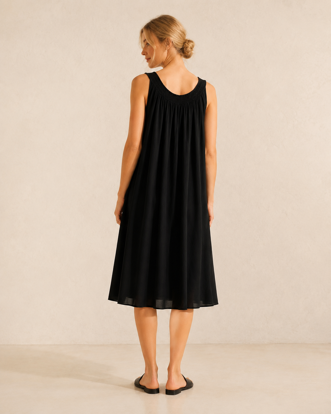 Vestido Adela negro, vista trasera con modelo rubia