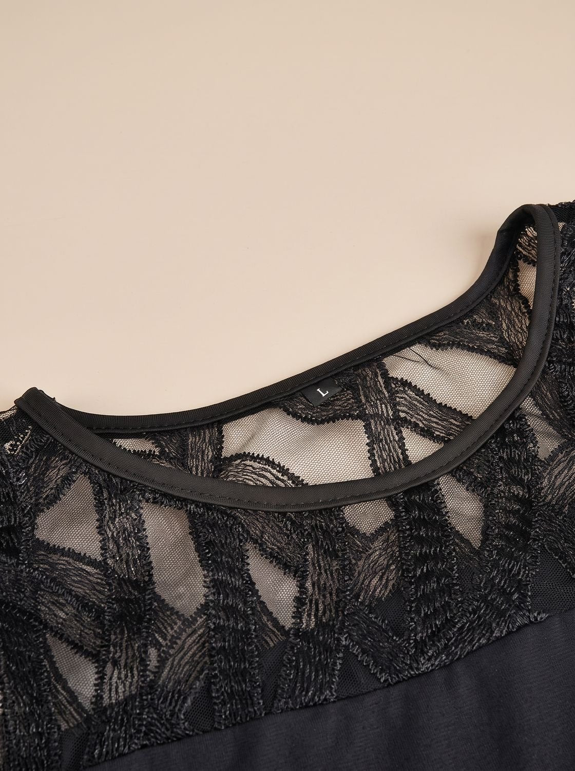 Detalle del escote y encaje geométrico negro del vestido Adriana